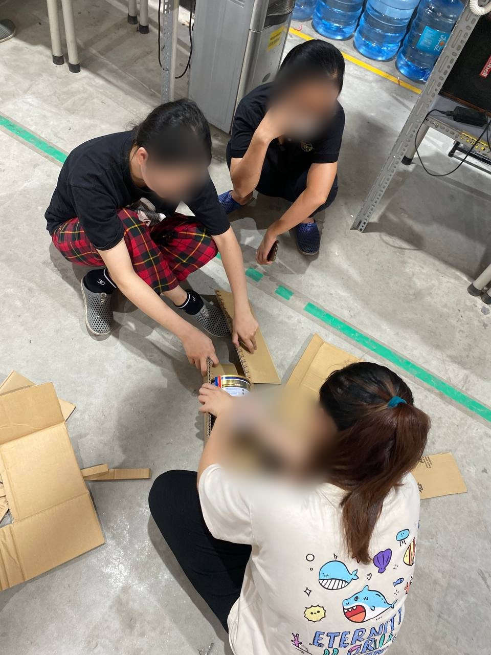 Buổi thử nghiệm quy cách đóng gói lon sữa: cắt thử bìa carton, đo và gấp sao cho lon không bị móp méo khi vận chuyển