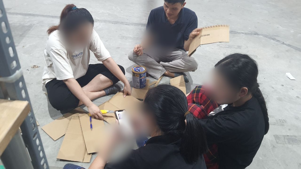Cả nhóm cùng thử các phương án gấp bìa carton cho lon sữa trước khi chốt quy cách đóng gói